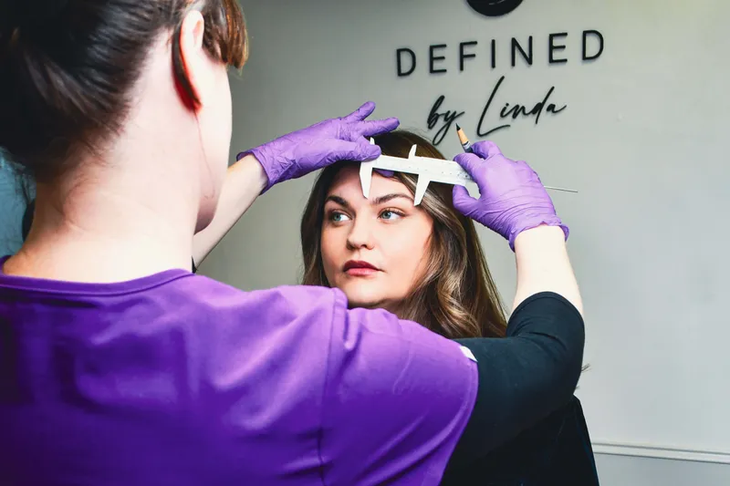 Linda carefully mapping a client's brow shape ahead of a combination brows treatment