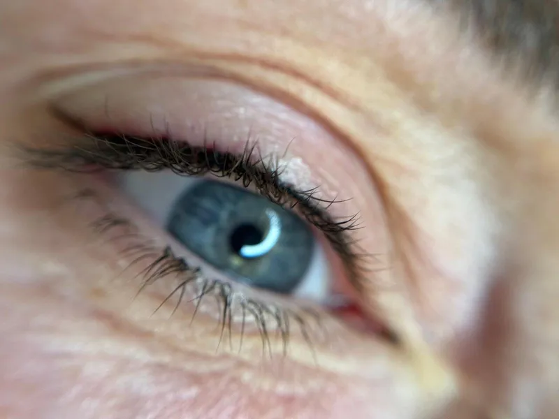 Extreme close-up of an eye showing a soft, defined permanent eyeliner result