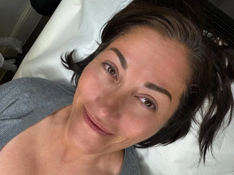 A smiling client after her semi-permanent brow treatment